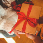 A group of friends exchanging beautifully wrapped gifts during a holiday party.