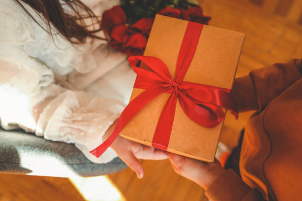 A group of friends exchanging beautifully wrapped gifts during a holiday party.